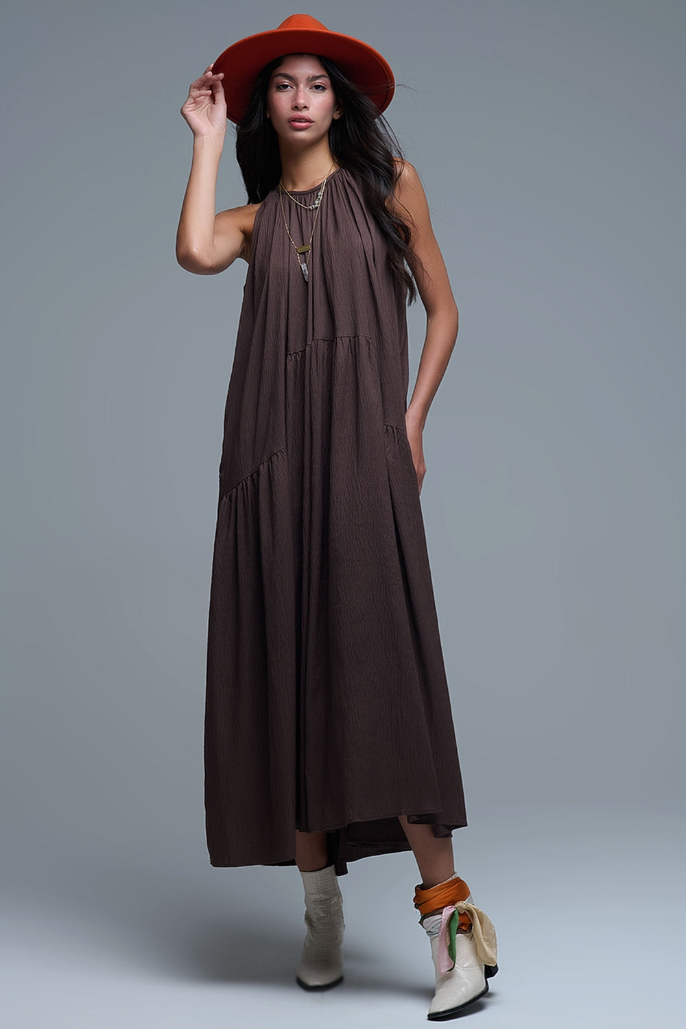 Mujer con vestido marrón largo de cuello halter