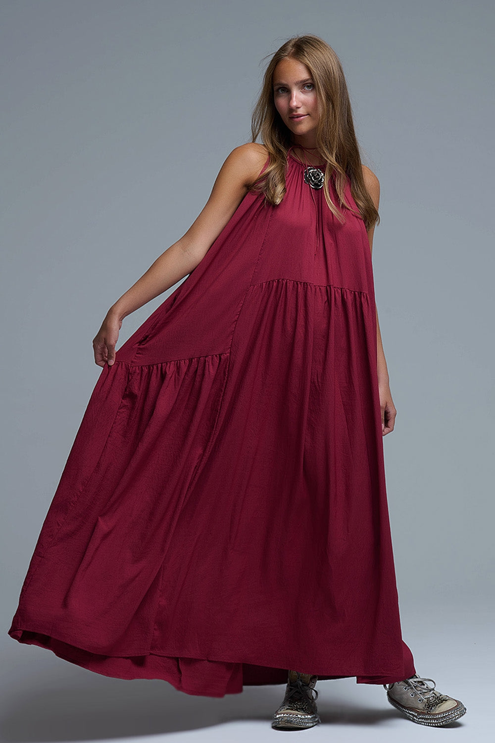 Vestido largo de color burdeos con cuello halter y silueta maxi muy holgada, paneles fruncidos con caída fluida y bolsillos laterales ocultos.