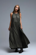 Vestido largo de color verde caqui con cuello halter y silueta maxi muy holgada, paneles fruncidos fluidos y bolsillos laterales ocultos.