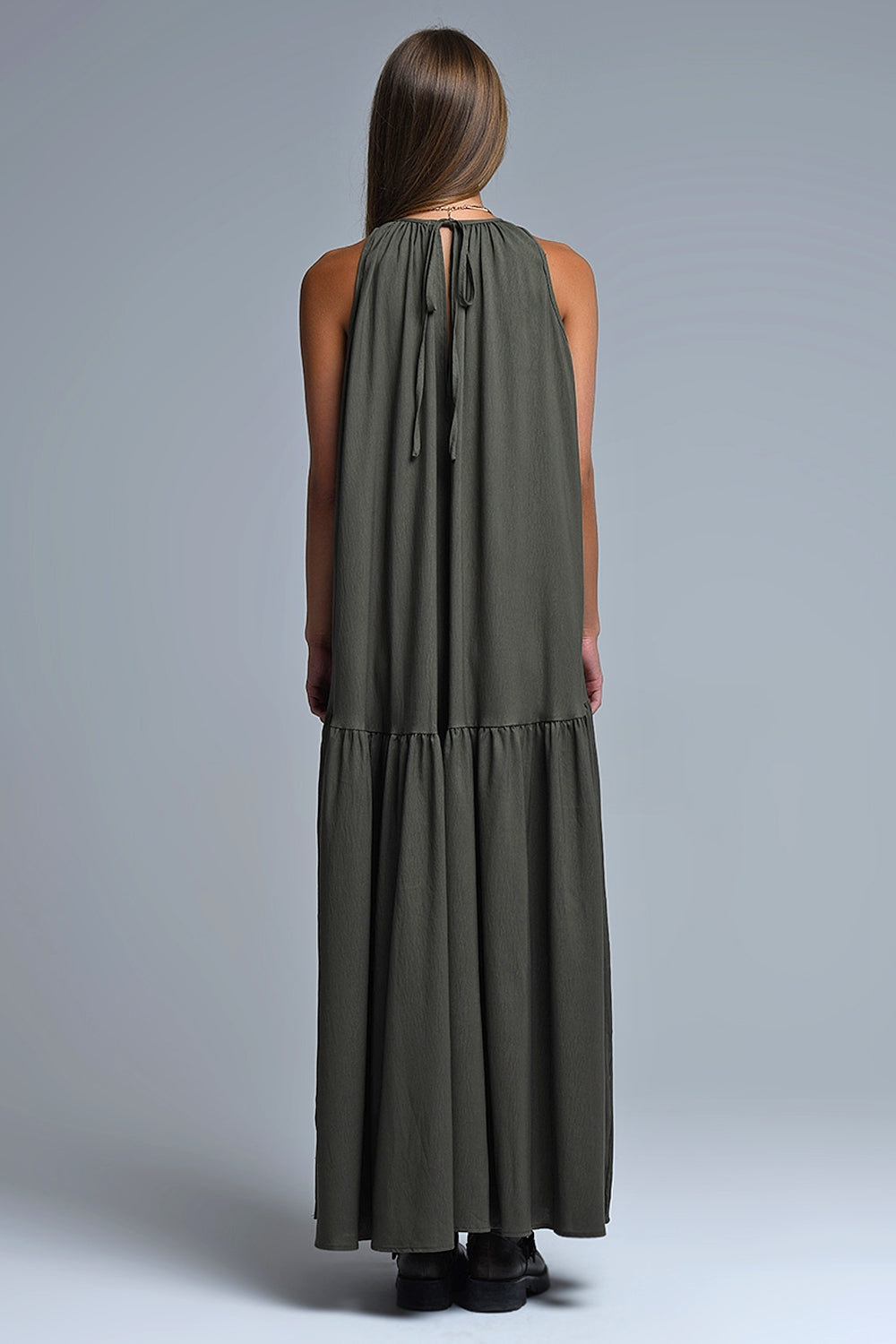 Vestido largo de color verde caqui con cuello halter y silueta maxi muy holgada, paneles fruncidos fluidos y bolsillos laterales ocultos.