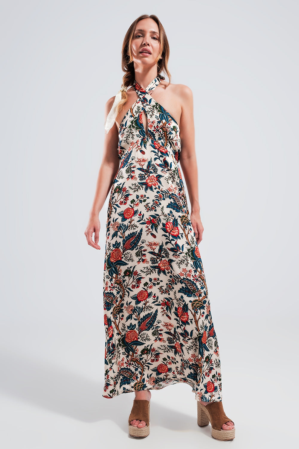 Mujer con vestido maxi halter de viscosa 100%, estampado floral jacobeo en crema y rojo, espalda descubierta, con sandalias de cuña de esparto