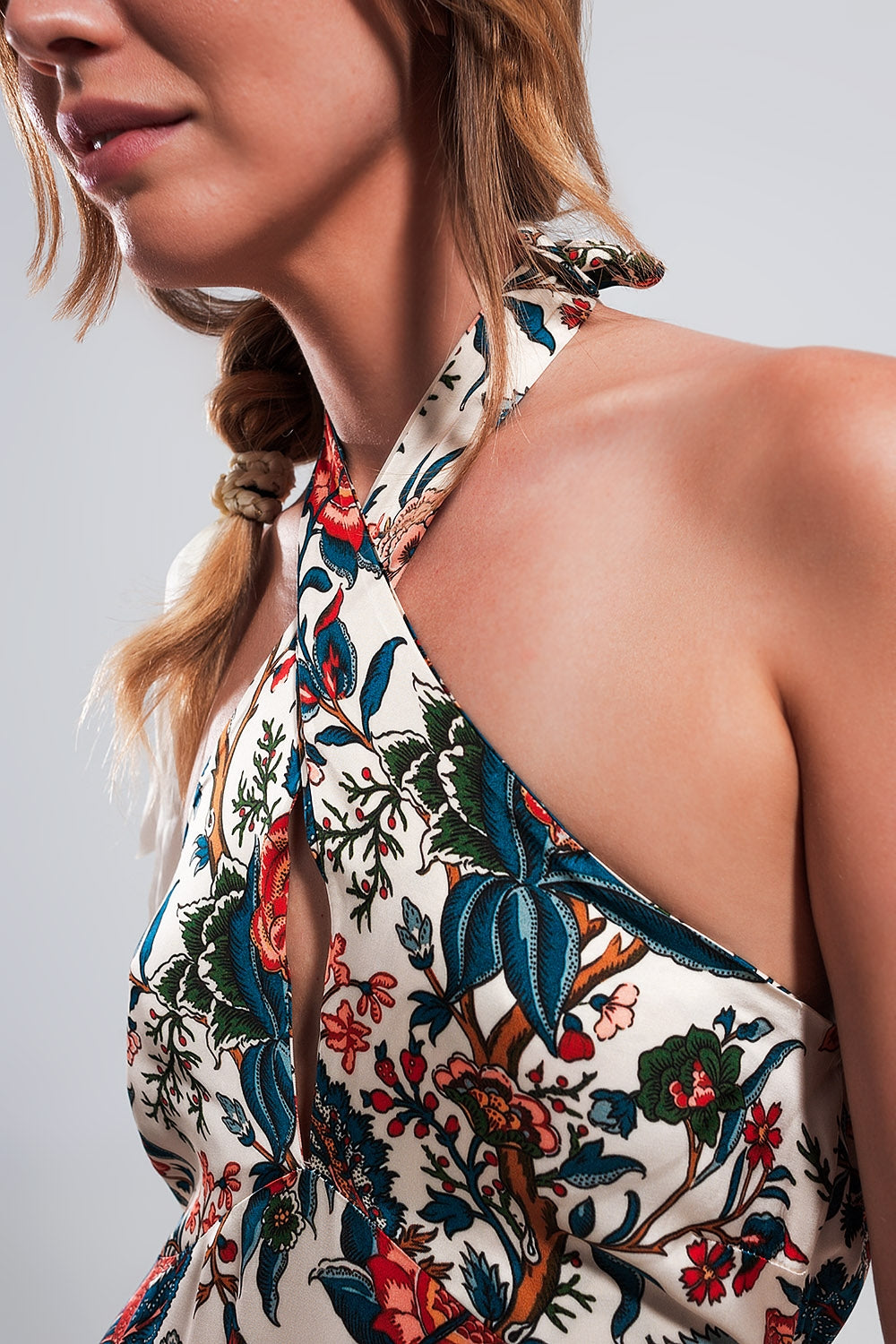 Mujer con vestido maxi halter de viscosa 100%, estampado floral jacobeo en crema y rojo, espalda descubierta.