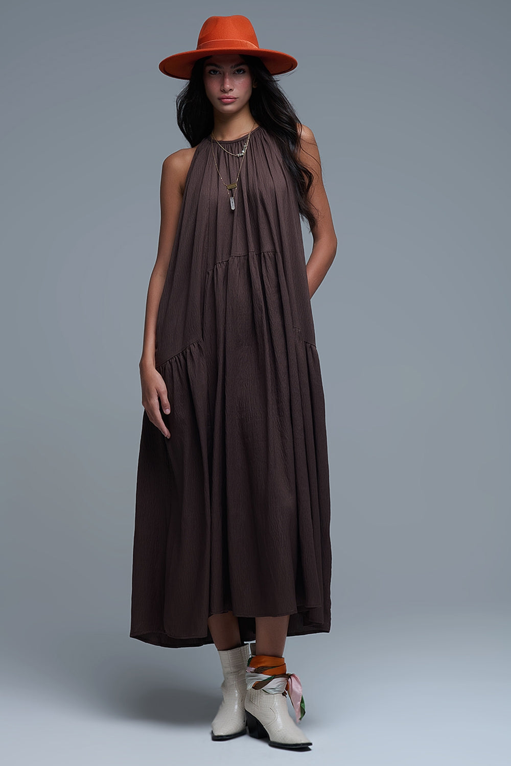 Vestido largo de color marrón chocolate con cuello halter y silueta maxi muy holgada, paneles fruncidos fluidos y bolsillos ocultos.