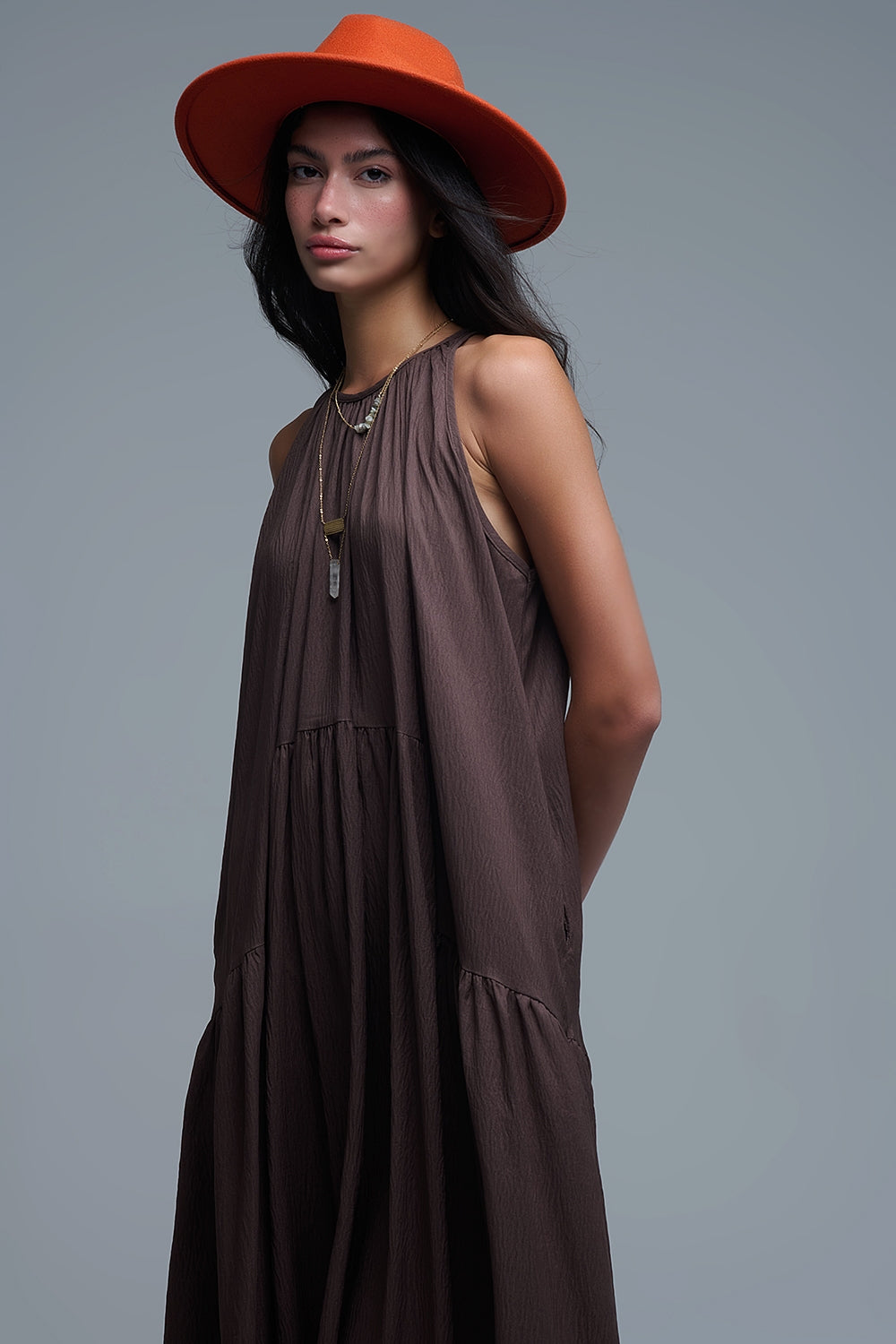 Vestido largo de color marrón chocolate con cuello halter y silueta maxi muy holgada, paneles fruncidos fluidos y bolsillos ocultos.