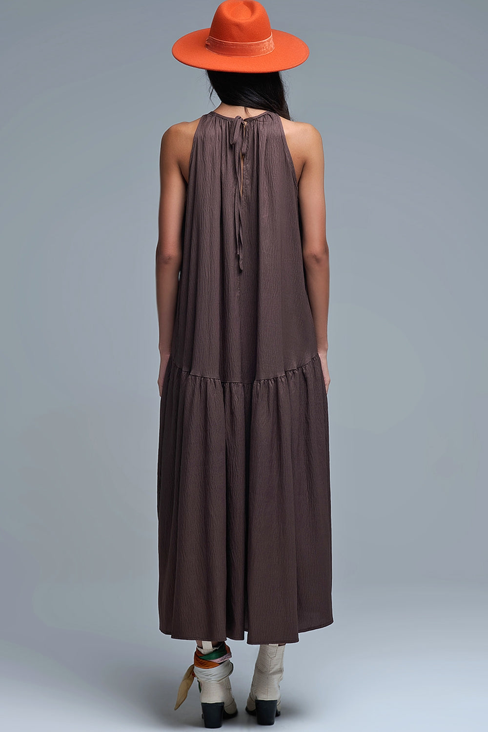 Vestido largo de color marrón chocolate con cuello halter y silueta maxi muy holgada, paneles fruncidos fluidos y bolsillos ocultos.