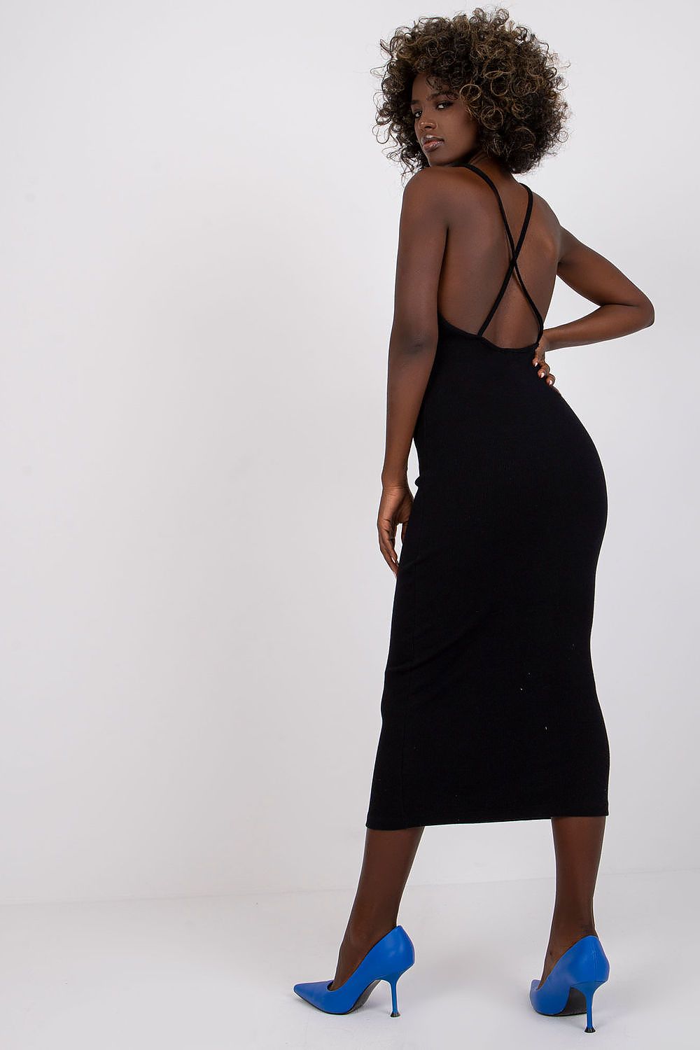 Detalle de espalda cruzada en vestido midi negro, con tacones azul eléctrico.