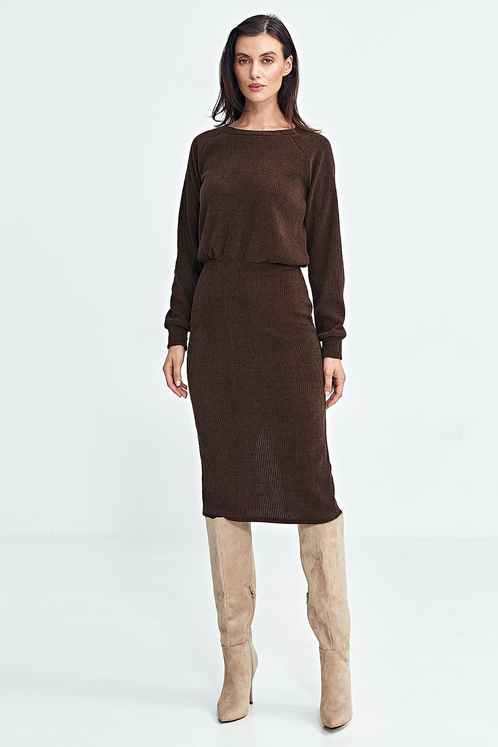 Modelo con vestido midi de punto acanalado en color marrón chocolate de efecto dos piezas, combinado con botas altas de ante beige.