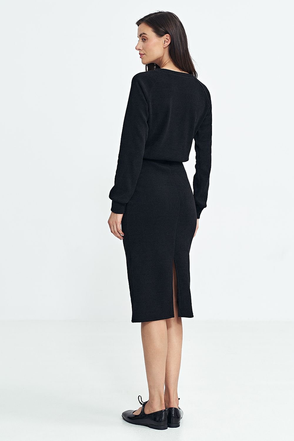 Vista trasera de un vestido de punto midi negro con abertura en la falda y detalle de la espalda.