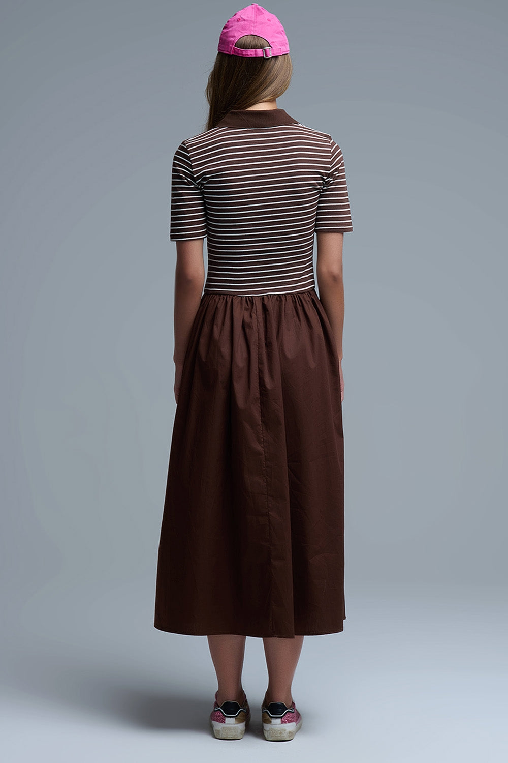 Espalda del vestido marrón con top de rayas y falda lisa midi.
