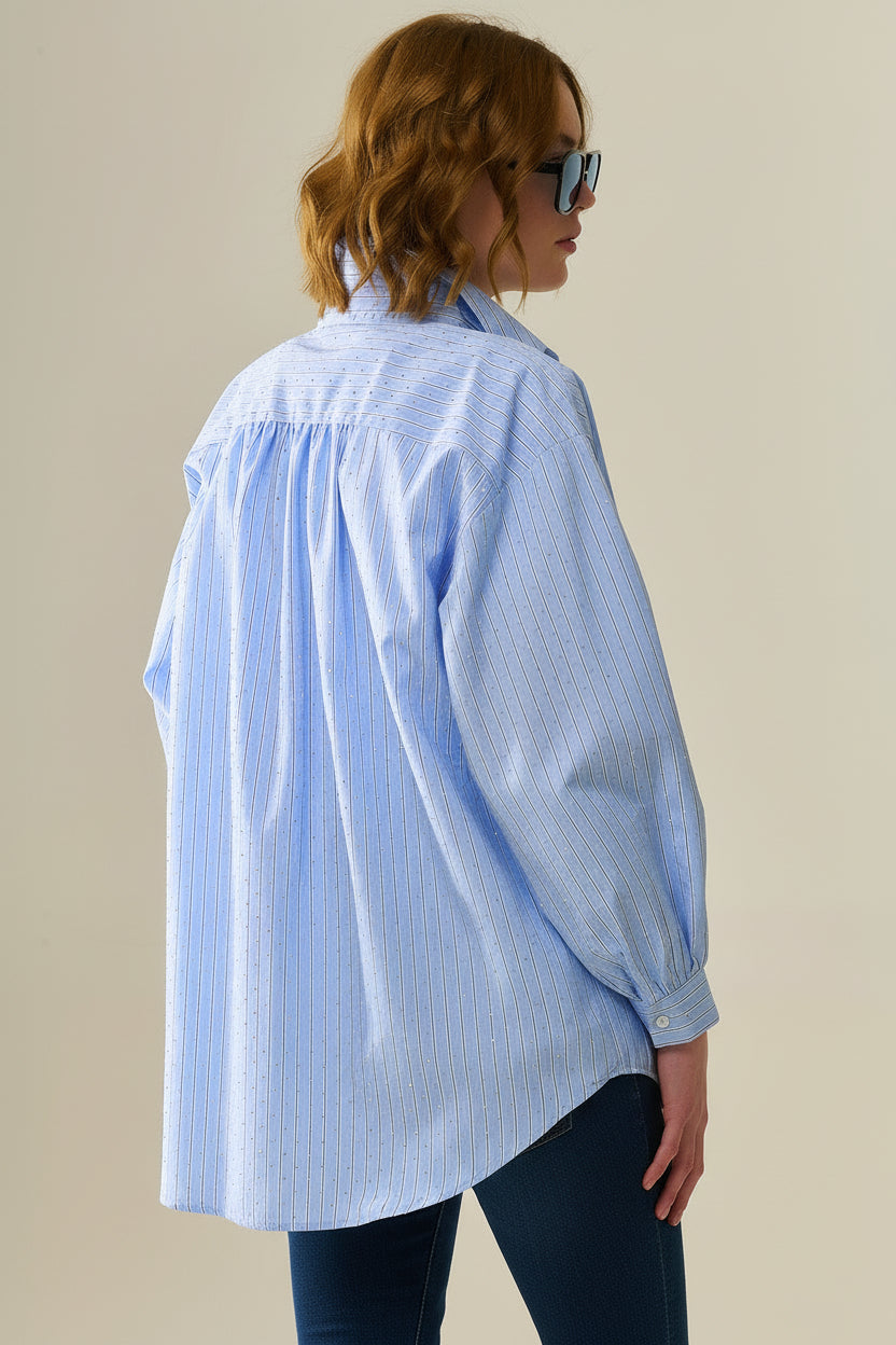 Parte trasera de camisa oversize a rayas azules mostrando los pliegues en la espalda y el corte amplio.