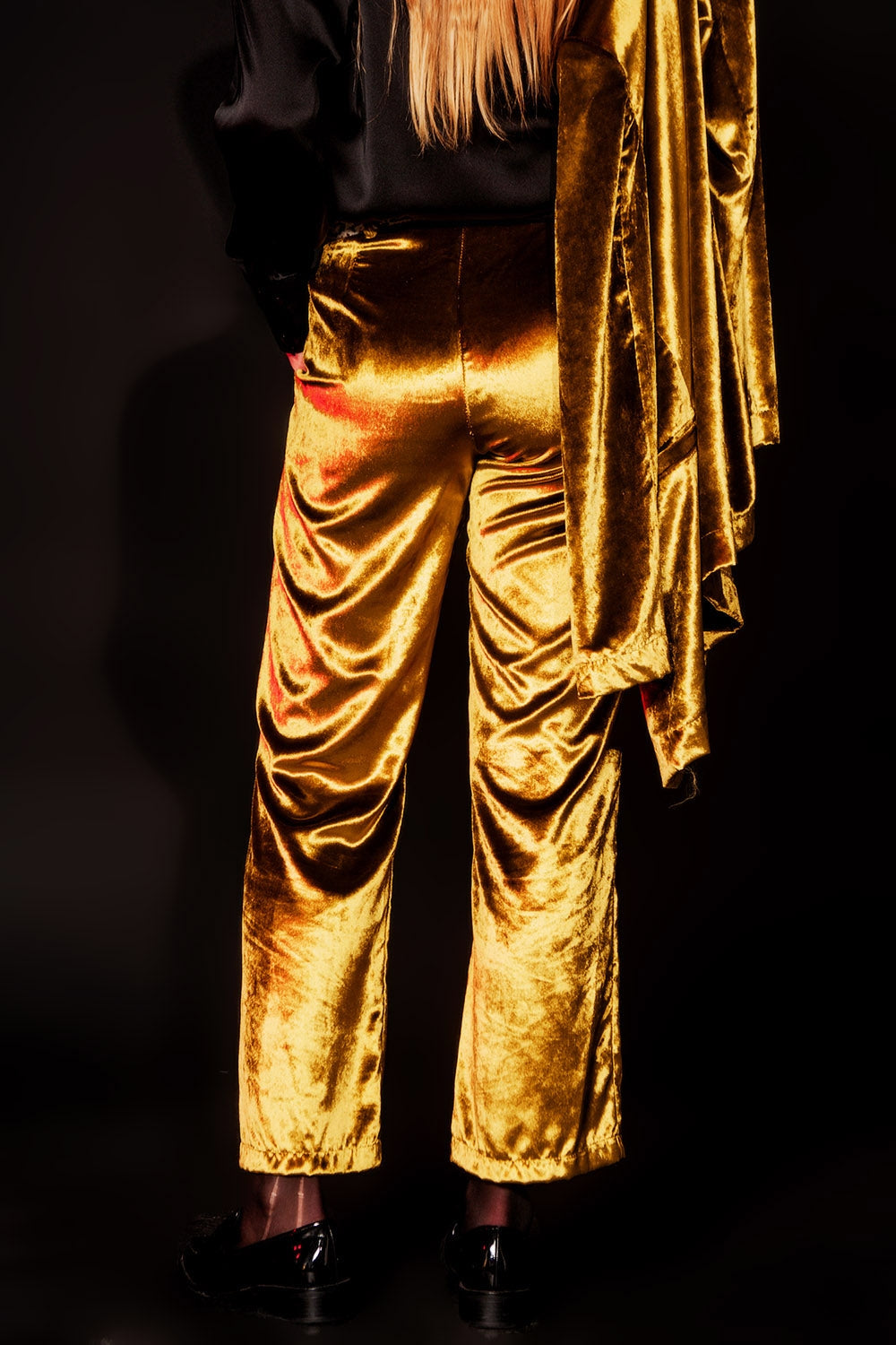 Parte trasera de unos pantalones de terciopelo lima brillante con caída fluida.
