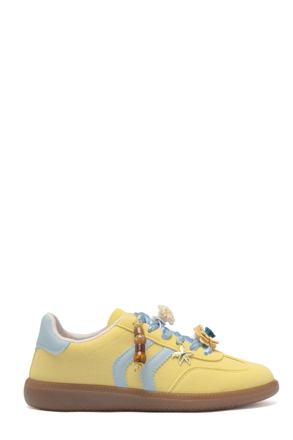Zapatilla deportiva de mujer efecto antelina amarillo pastel con cordones celestes de satén, detalles de flores 3D y suela de goma.