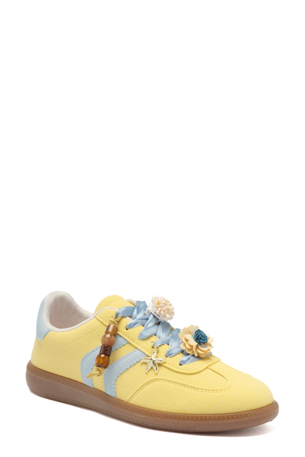Zapatilla deportiva de mujer efecto antelina amarillo pastel con cordones celestes de satén, detalles de flores 3D y suela de goma.