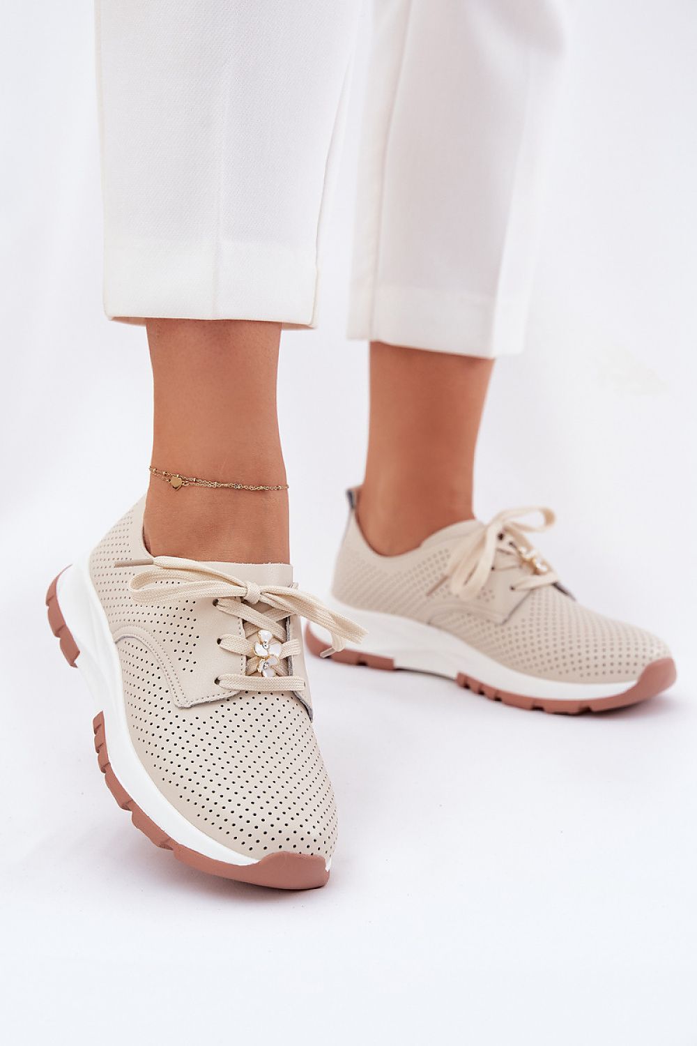 Zapatillas beige de piel calada con detalle floral, vista frontal