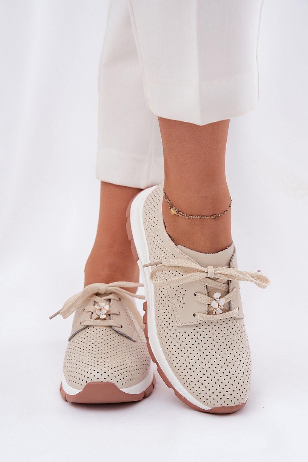 Zapatillas beige combinadas con pantalón blanco, estilo casual