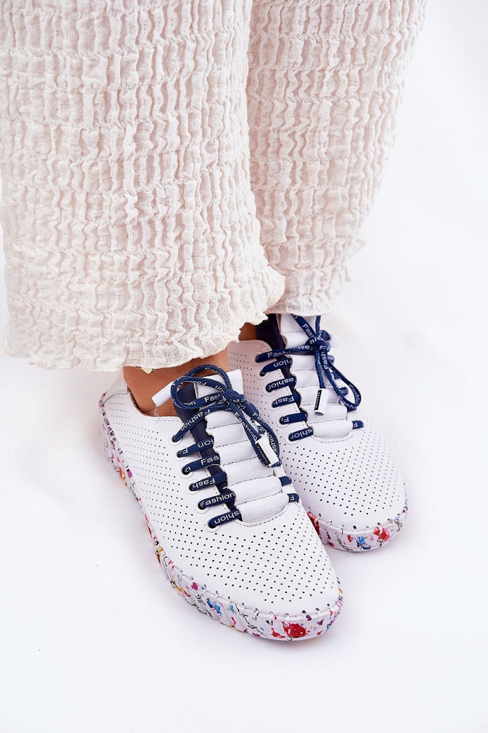 Look completo con pantalón claro y zapatillas blancas con cordones azul marino