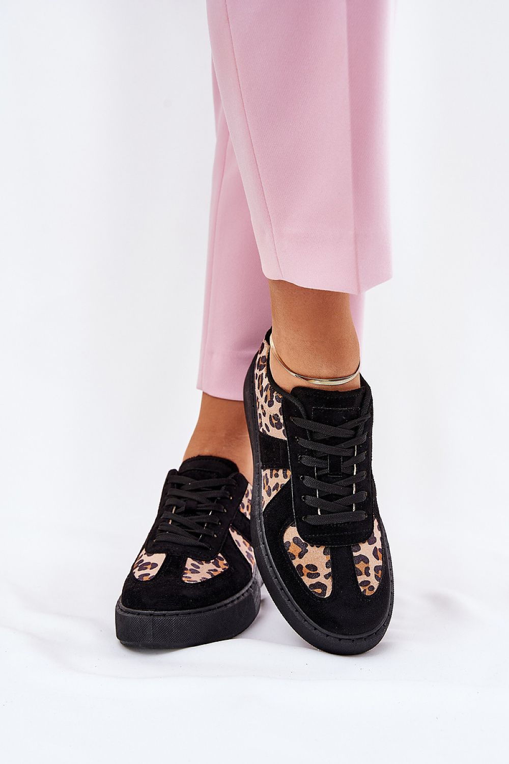Zapatillas negras de mujer con detalles leopardo, ideales para looks cómodos y modernos. 