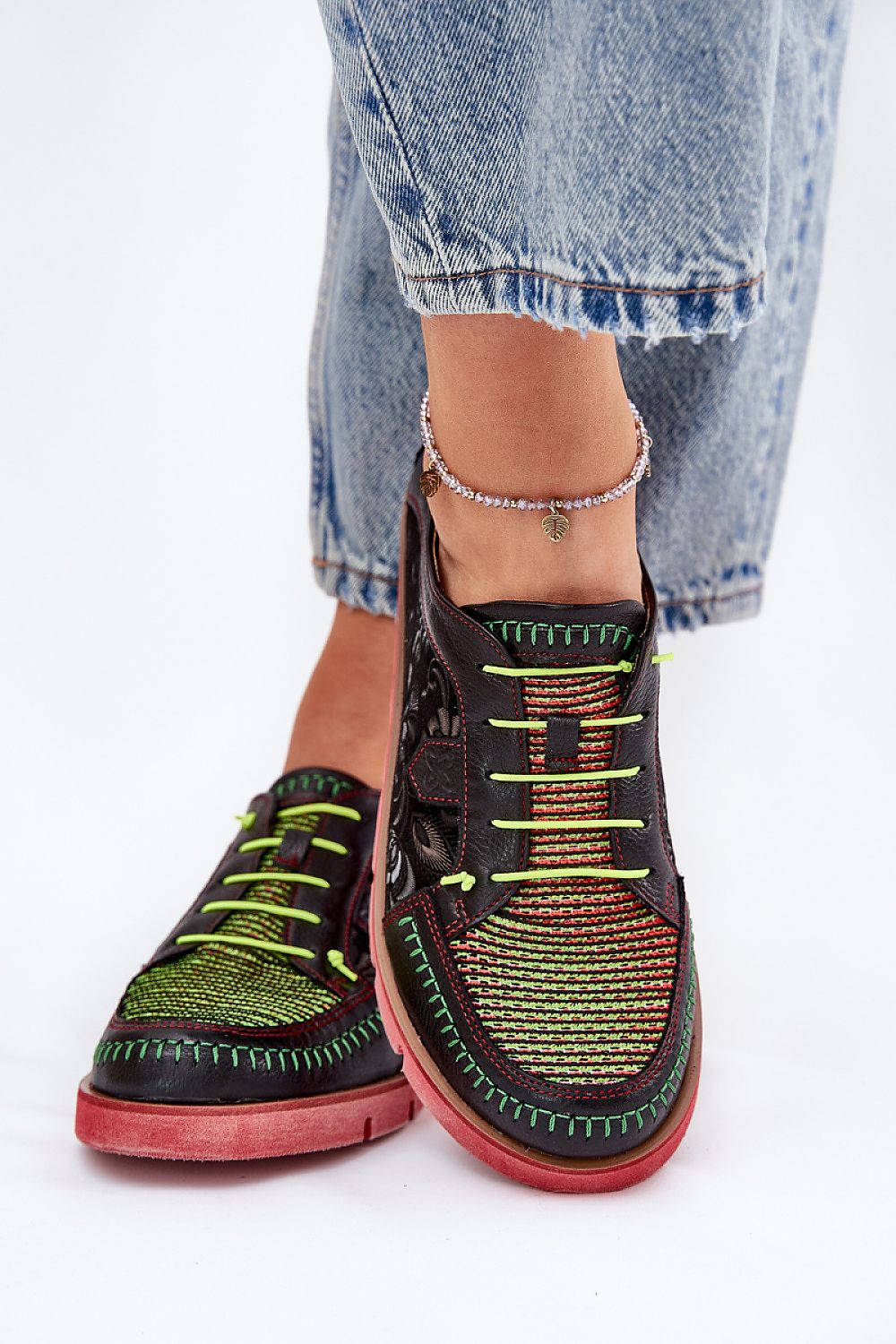 Zapatillas Maciejka negras con detalles verdes vistas de frente con pantalón denim