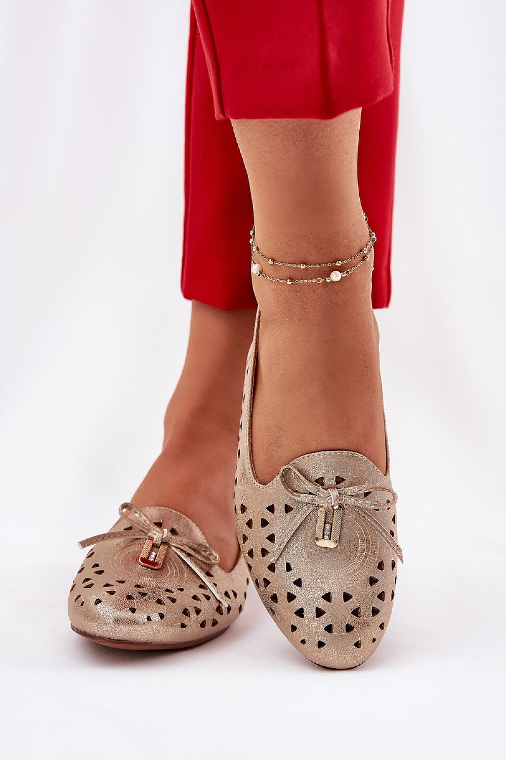 Zapatos planos dorados troquelados con lazo decorativo para mujer